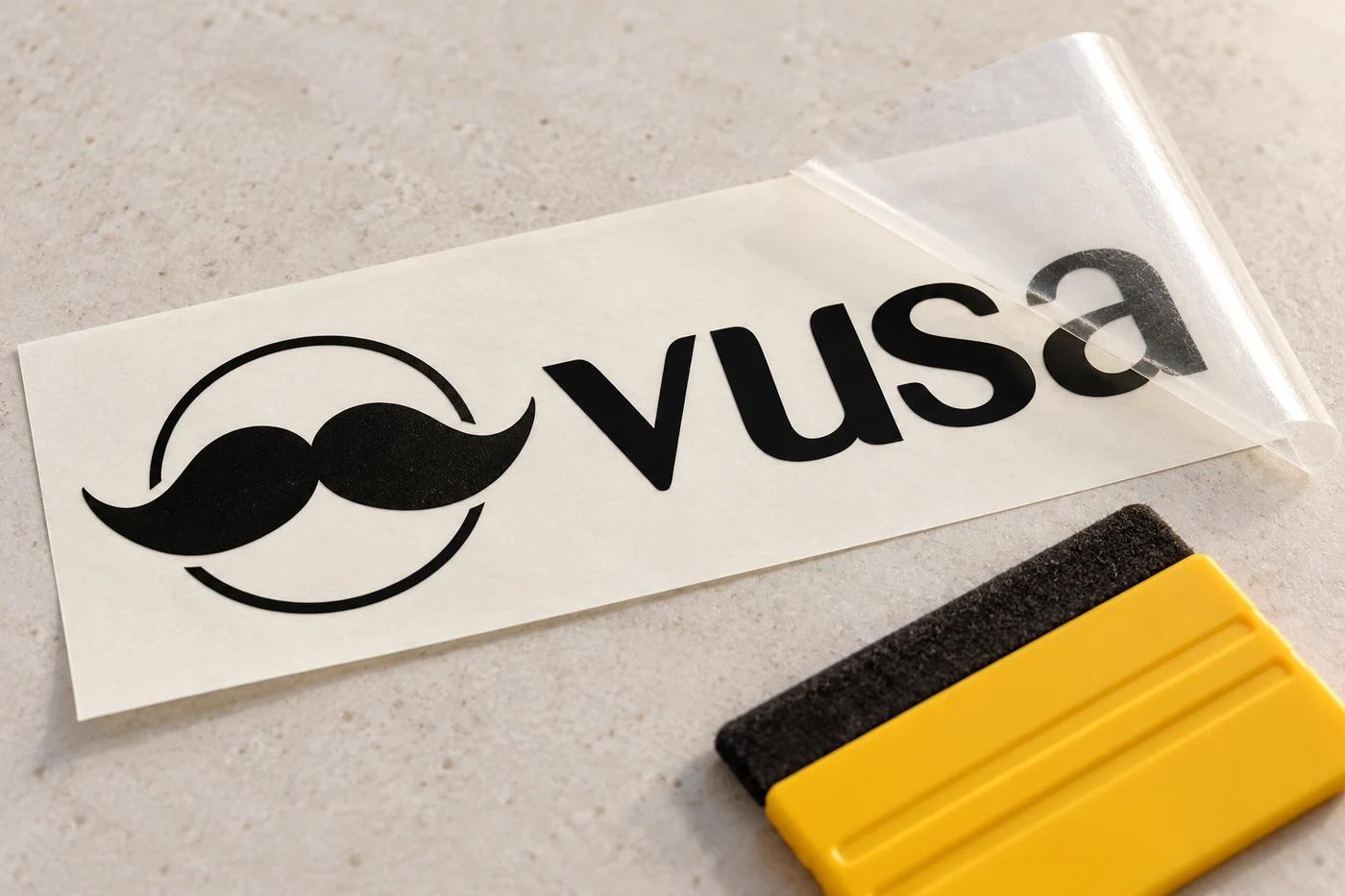 Detal wycinanego logo VUSA na folii transportowej